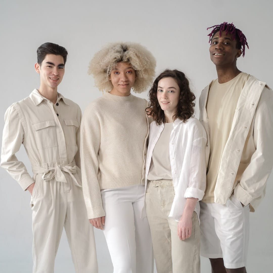  A cheerful, diverse group showcasing fashionable, sustainable clothing in a natural outdoor setting, emphasizing inclusive style and sustainability.